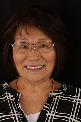 Beaming patient after missing tooth replacement using an implant-supported bridge.